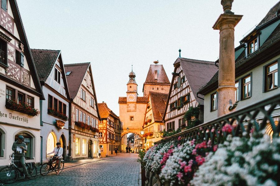 A flower-lined lane of half-timbered houses in a historic European old town