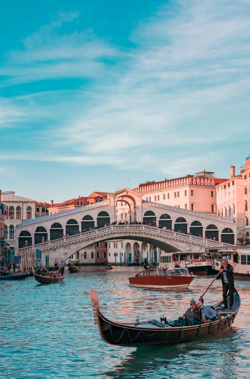 A gondola gliding along a Venice canal near the Rialto Bridge